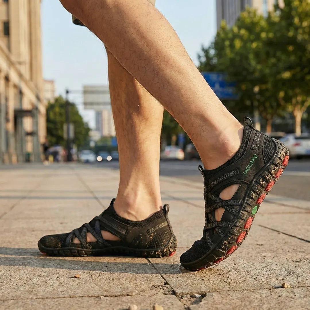 Pies en sandalias negras Breeze II en calle urbana.