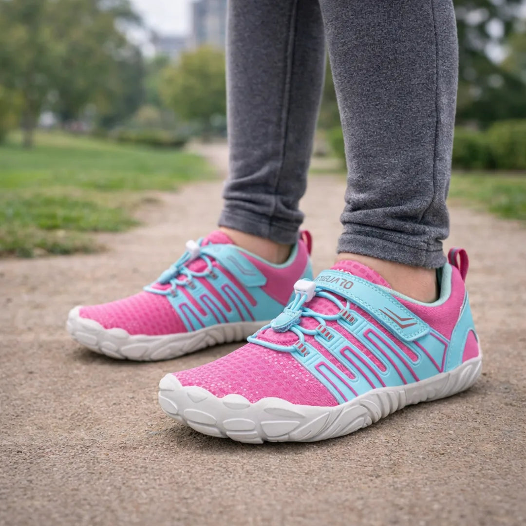 Vista de perfil de calzado barefoot para niña en tonos rosa y celeste de gran flexibilidad.