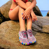 Persona usando las Saguaro Smart II rosa en la playa.