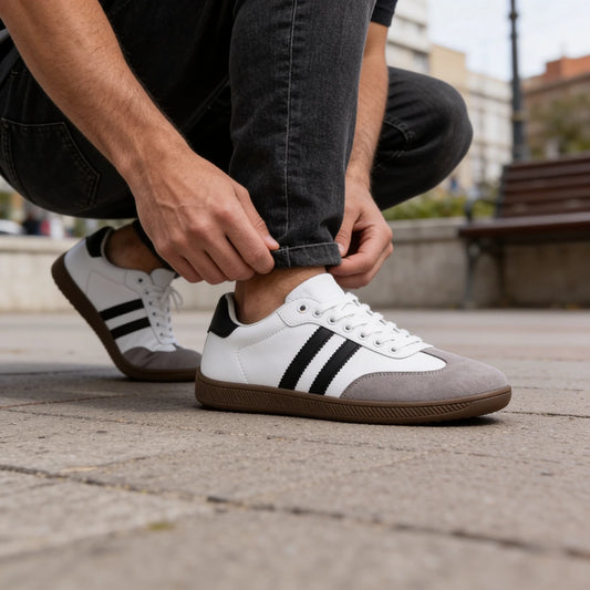 Primer plano de zapatillas anchas blancas para hombre con puntera de gamuza gris.