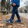 Niño caminando en una plaza usando zapatillas anchas infantiles Saguaro color azul.