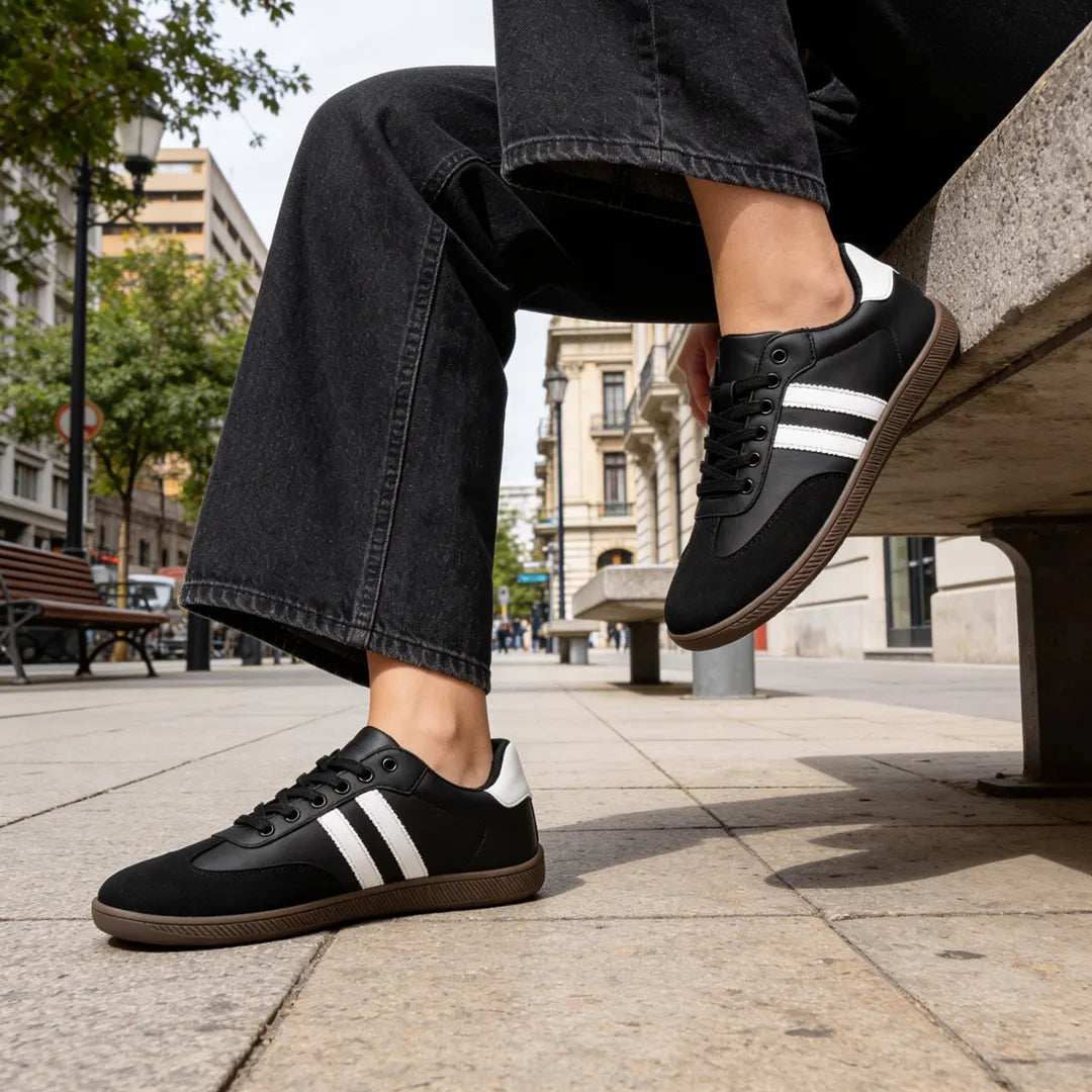 Zancada con zapatillas barefoot hombre negras resaltando la flexibilidad y estilo retro.